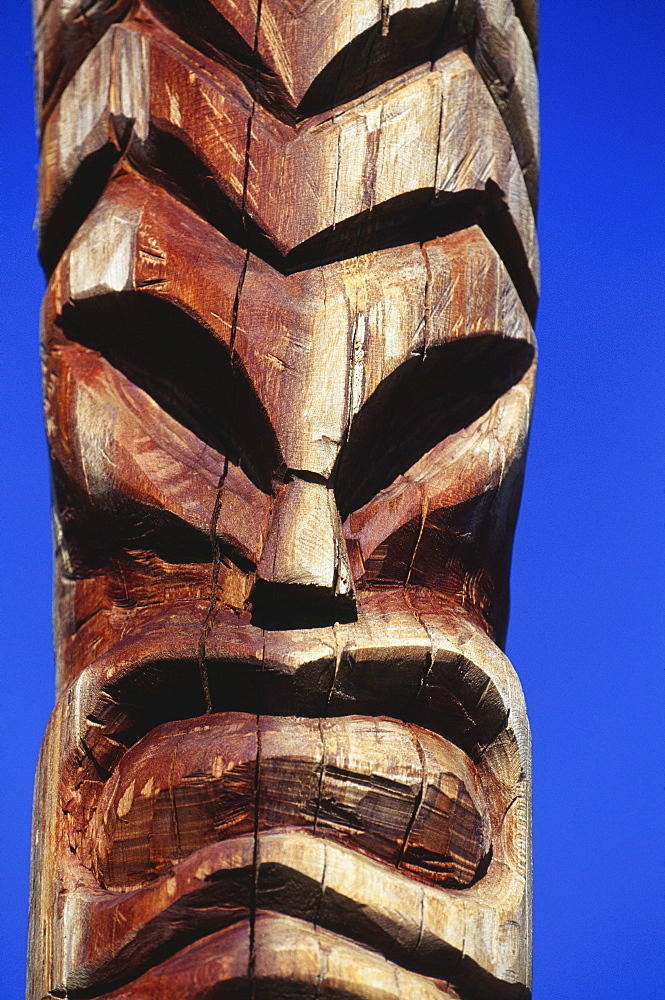 Hawaii, Maui, Lahaina Center, Hale Kahiko, closeup of wooden handcarved tiki, blue sky background