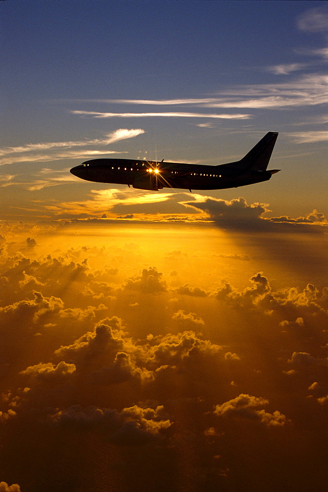 Airplane in silhouette, sun through window in sky, sunset B1177