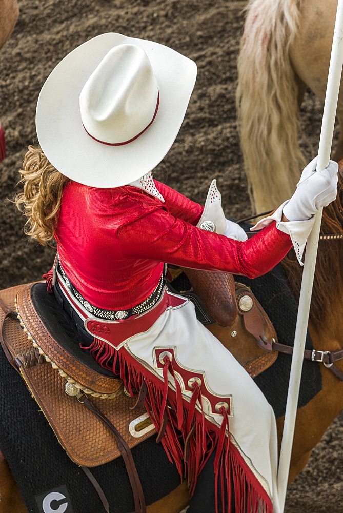 High angle view of a woman wearing a white cowboy hat and riding a horse at the Calgary Stampede, Calgary, Alberta, Canada