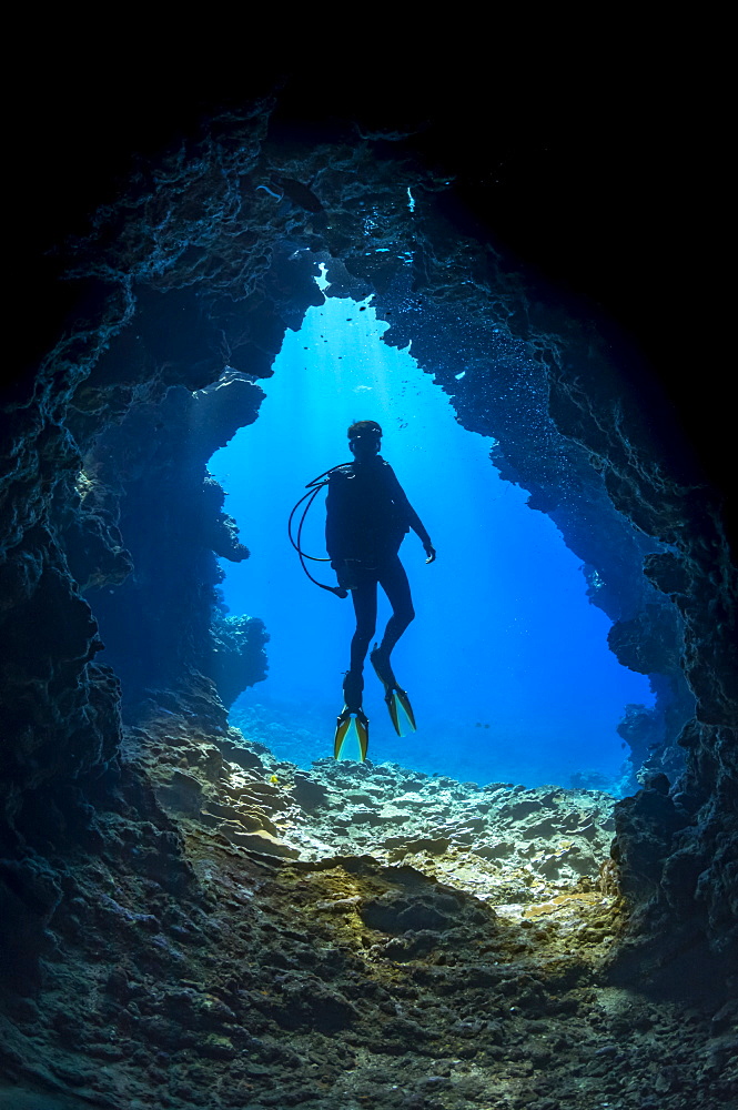 Diver at one of the many openings around the dive site called First Cathedral off the island of Lanai, Hawaii, United States of America