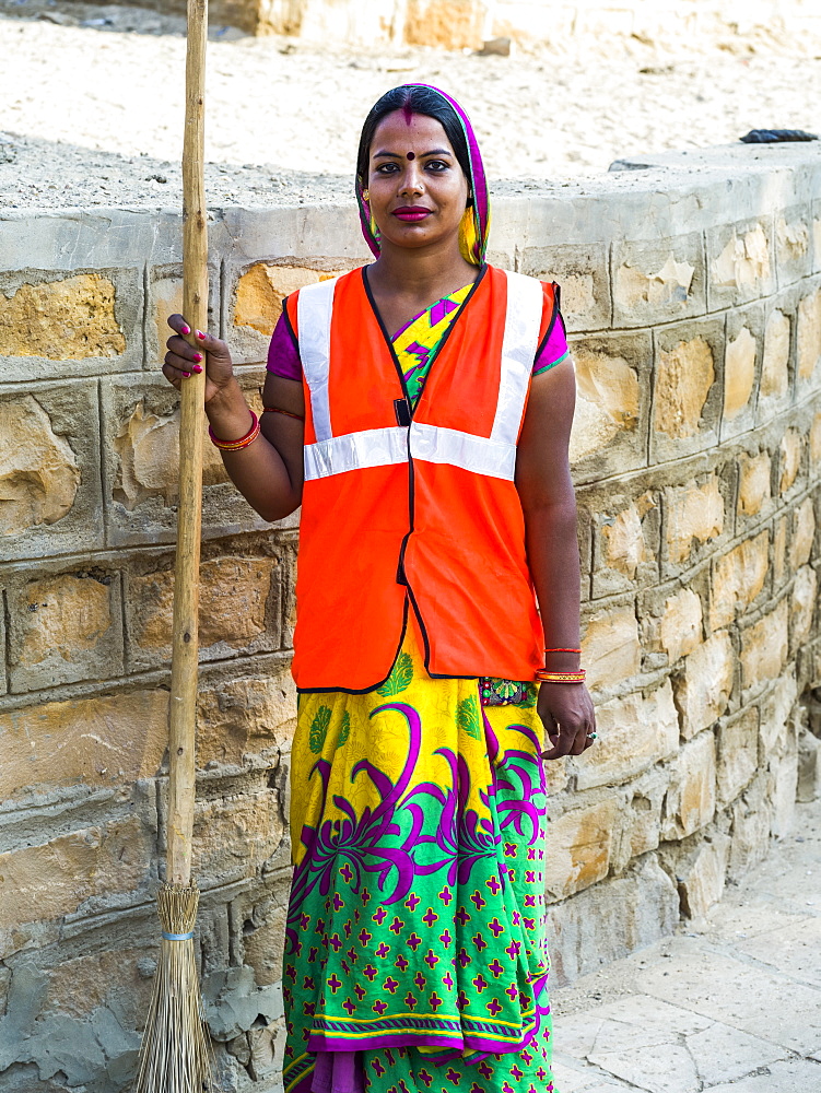 Portrait of an Indian woman wearing a reflective vest and holding a broom, Jaisalmer, Rajasthan, India