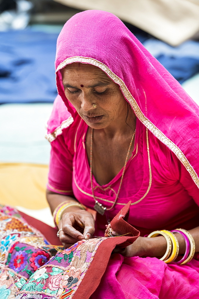 A Hindu Indian woman sits doing needlework, Fort Jaisalmer, Jaisalmer, Rajasthan, India