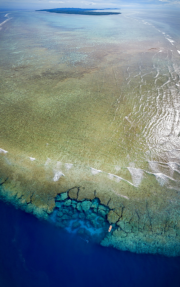 Aerial view of the southern end of the reef surrounding the island of Yap, with a dive boat anchored at Yap Caverns, a famous site for scuba divers, Ngariy, Yap, Micronesia