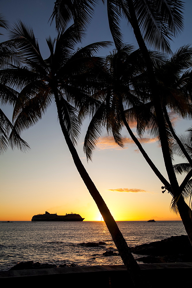 Silhouette of a cruise ship on the water off the shore of Kailua Bay at sunset, Kailua-Kona, Island of Hawaii, Hawaii, United States of America