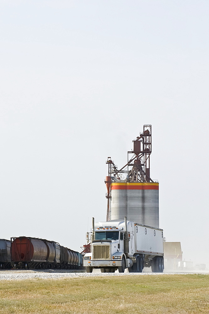 Truck leaving after hauling grain to an inland terminal, near Brunkild, Manitoba, Canada