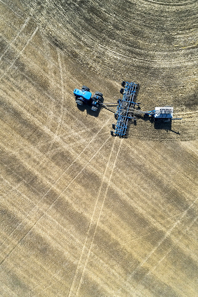 Aerial view of air seeder in field, near Beiseker, Alberta, Canada