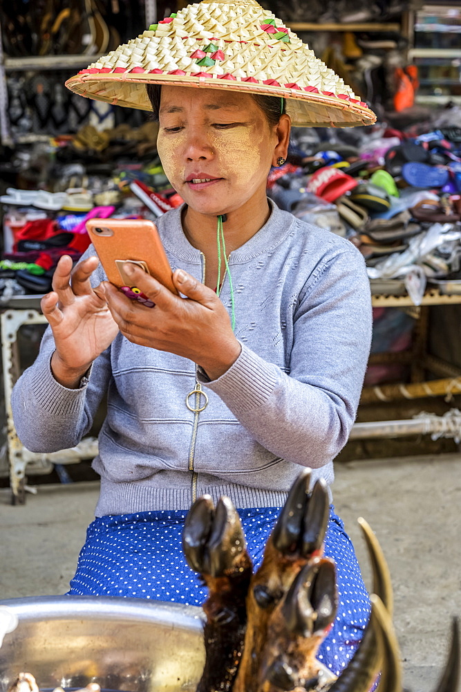 Woman on her smartphone at the market, Lashio, Shan State, Myanmar