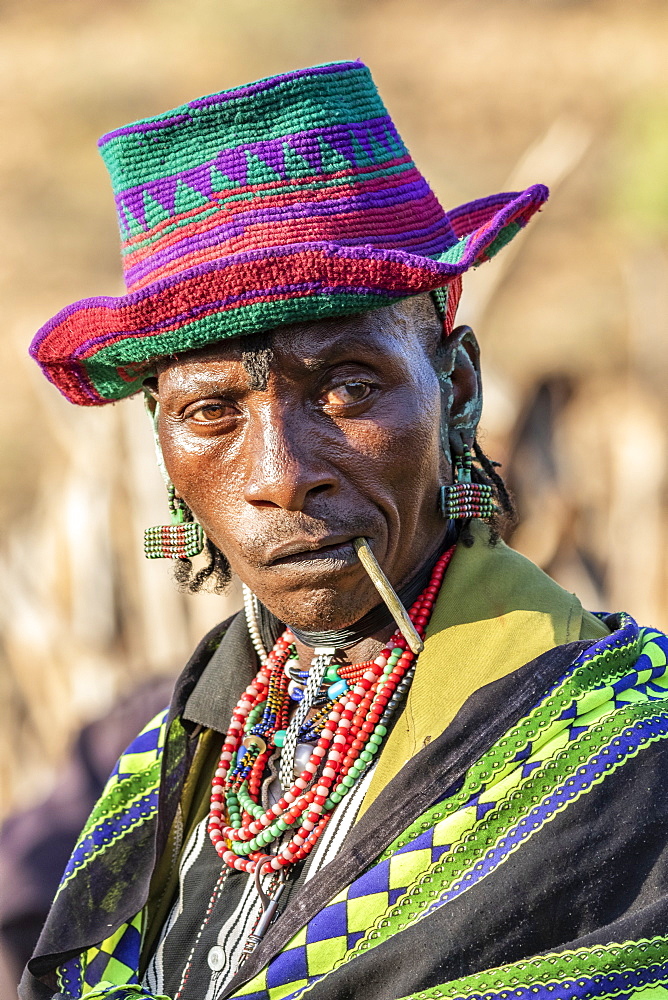 Hamer man wearing a colourful hat at a bull jumping ceremony, which initiates a boy into manhood, in the village of Asile, Omo Valley, Ethiopia