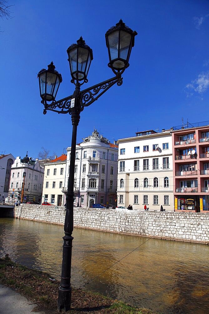 Ornate lamp post and buildings on bank of Miljacka River, Sarajevo, Bosnia and Herzegovina, Europe