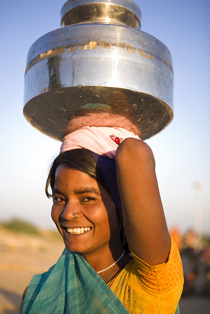 Young woman collecting water, Jaisalmer, Western Rajasthan, India, Asia