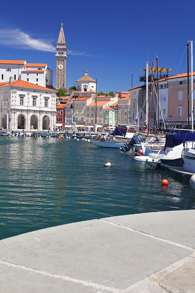 Waterfront buildings at the harbour and bell tower of Cathedral of St. George, Piran, Istria, Slovenia, Europe