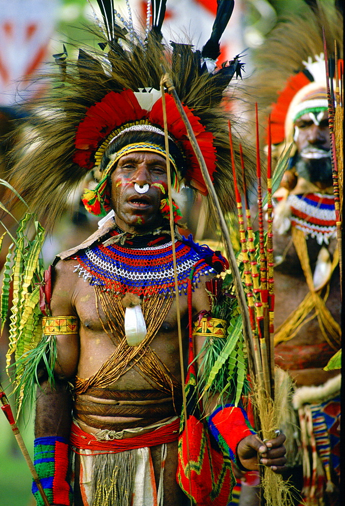 Bearded tribesman wearing war paints and feathered headdress during  a gathering of tribes at Mount Hagen in Papua New Guinea