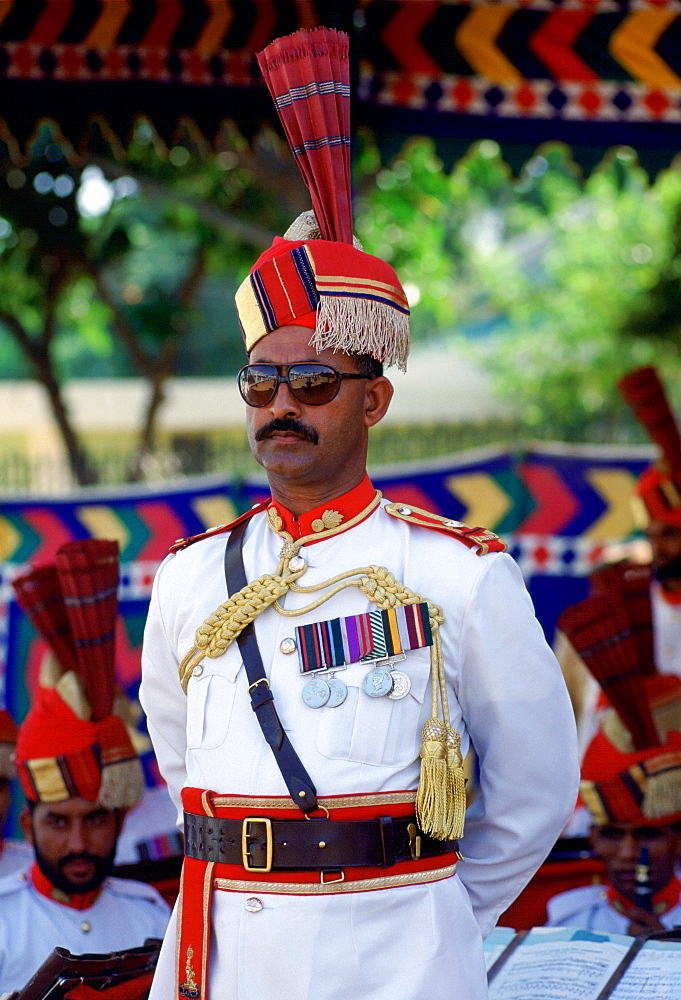 Military man with medals standing at ease watching a parade in Pakistan