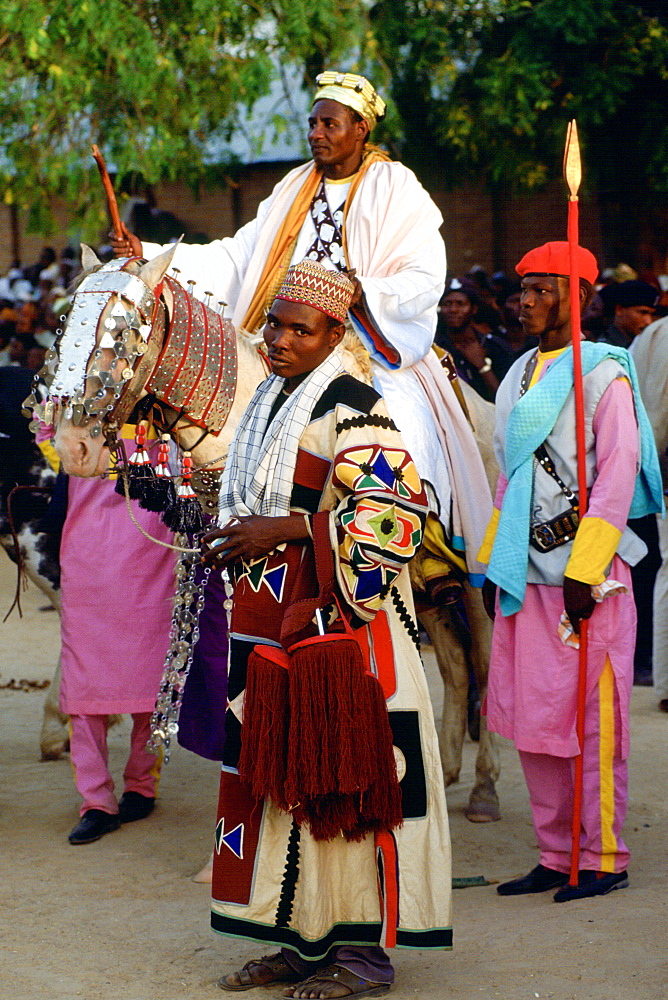 A n honoured chief riding a decorated horse with his attendants at a Durbar in Maidugari, Nigeria