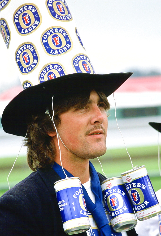 Racegoer  wearing a ' Fosters Lager' hat to  the Melbourne Cup Race Day, Australia