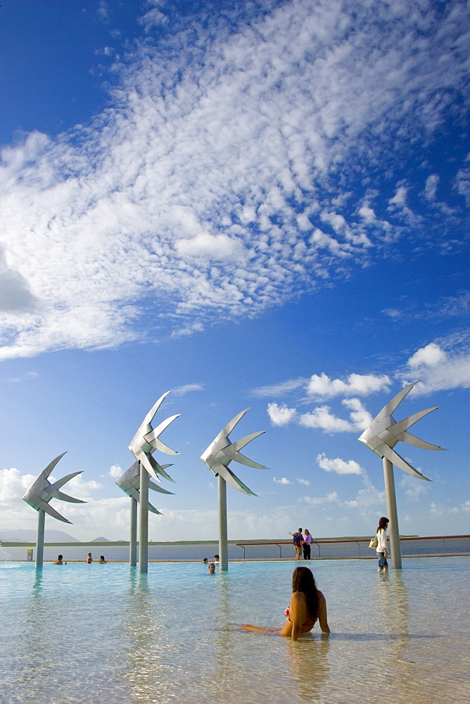 Young woman sunbathes in the Cairns Esplanade Lagoon, a waterpark in Queensland