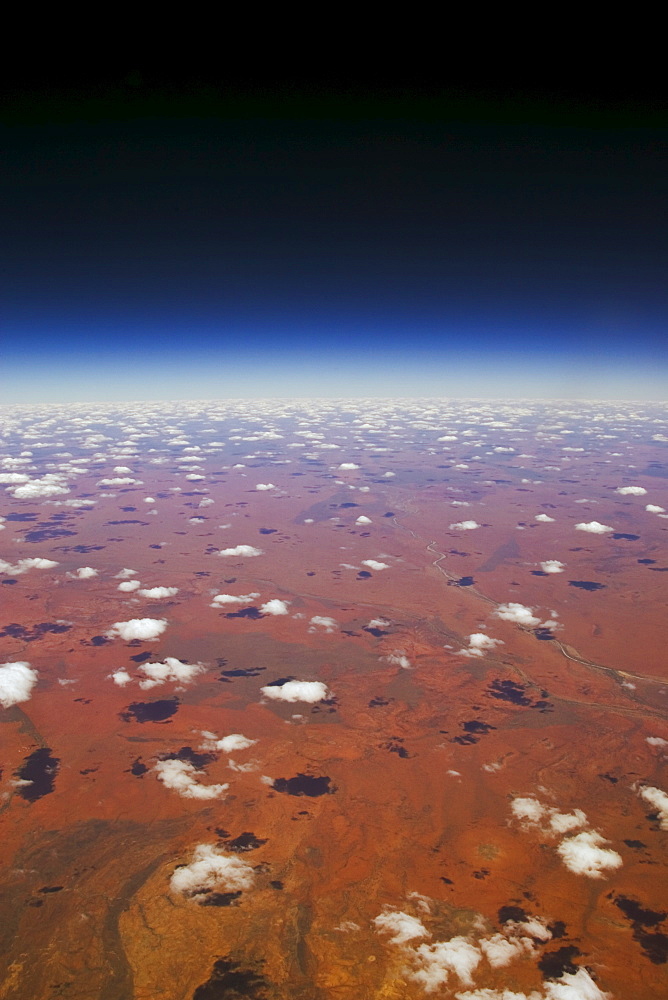 Red Centre viewed from aeroplane showing clouds and red earth over central Australia