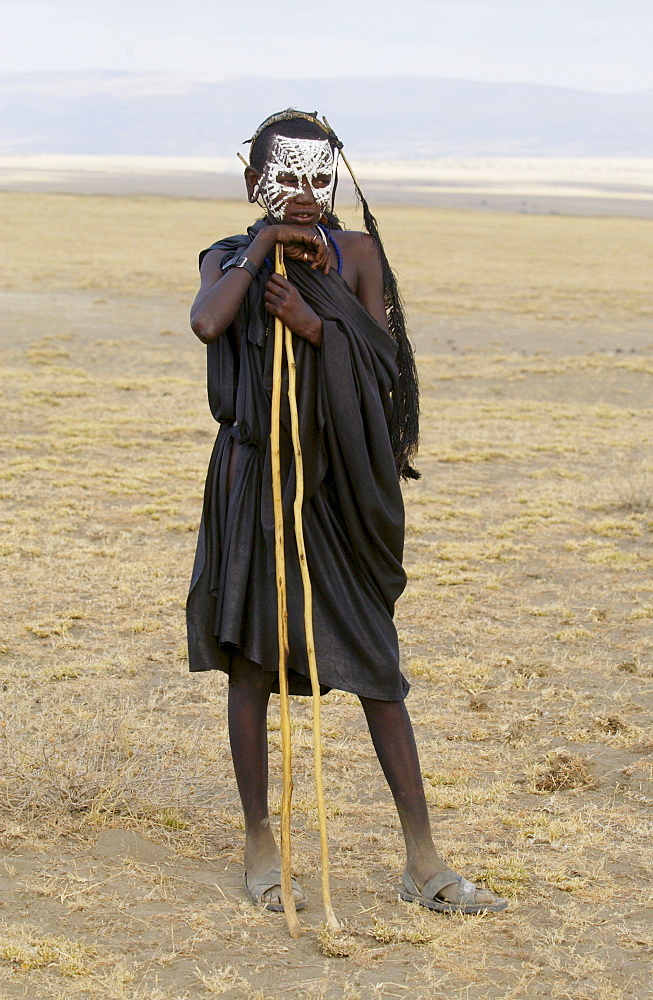 Young Masai recently cirumsised wears white make-up markings and black robes until in a few weeks he adopts the full red colourful robes of a Masai Warrior