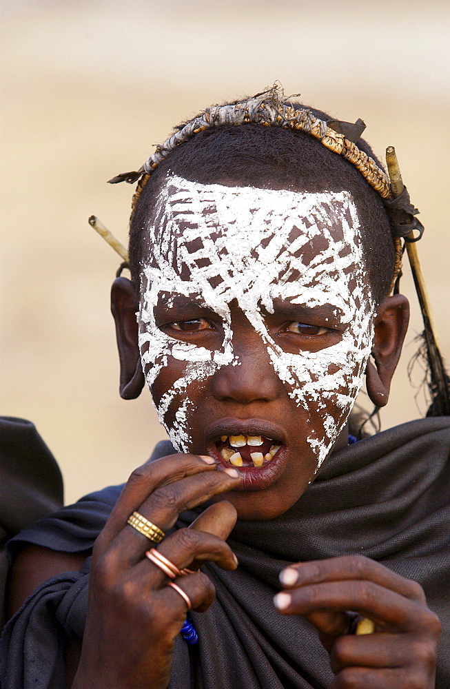 Young recently circumcised Masai Warrior (moran) with traditional face paint after 'coming of age'  in the Serengei Plains, Tanzania