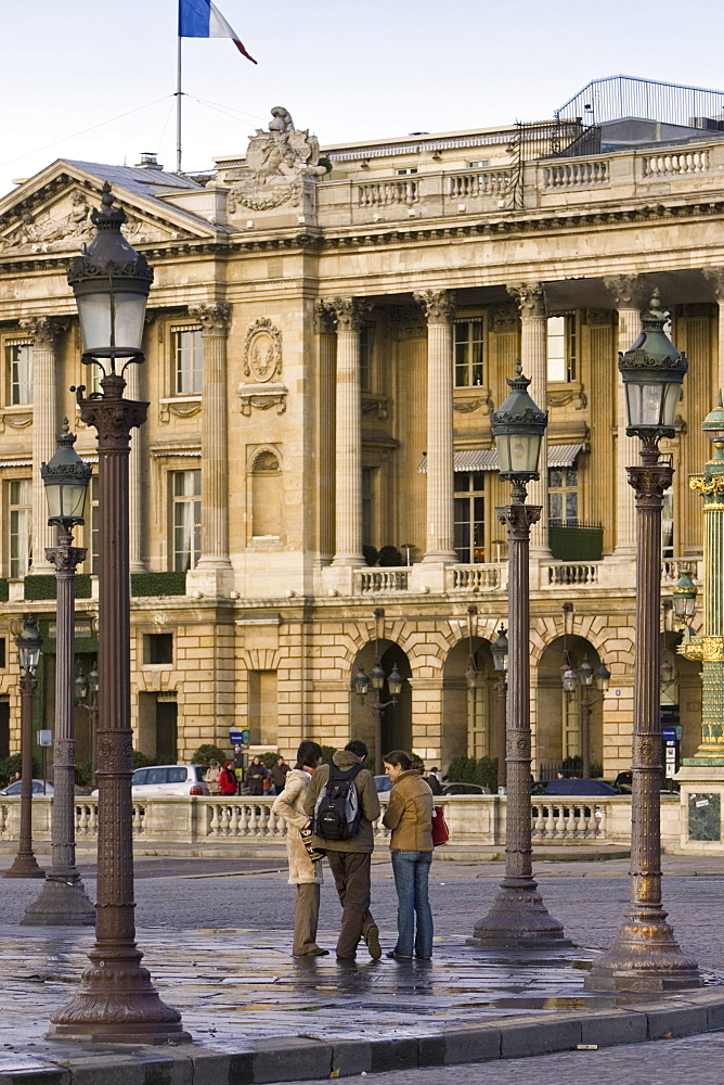 Tourists talking on street corner in front of Hotel de Crillon in Place de la Concorde, Central Paris, France