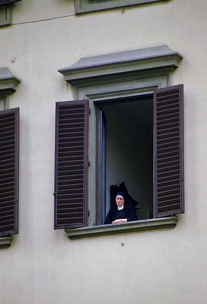 Catholic nun stands at a window in the Vatican, Vatican City State