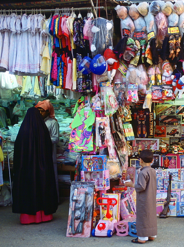 Small child gazing at toys in the market, Kuwait