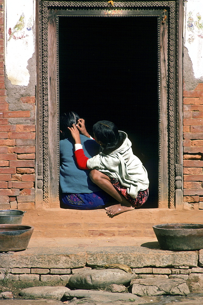 Young girls inspecting for nits, Patan, Nepal.