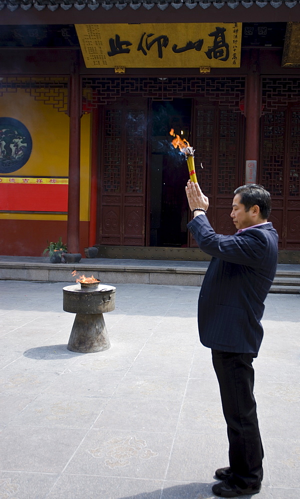 Worshipper burning incense at the Jade Buddha Temple, Shanghai, China