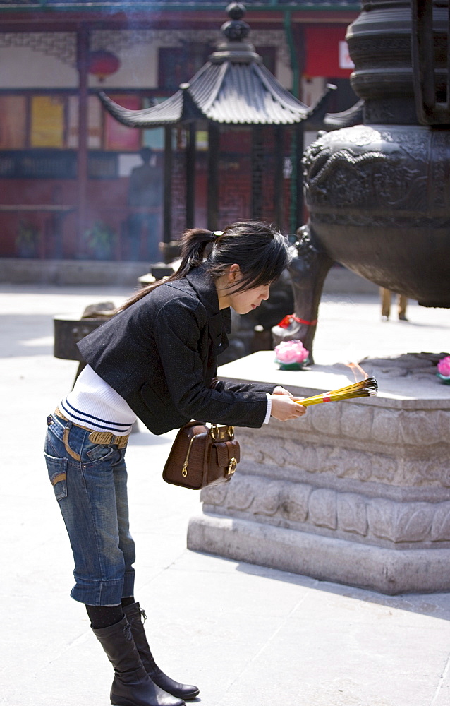 Worshipper burning incense at the Jade Buddha Temple, Shanghai, China