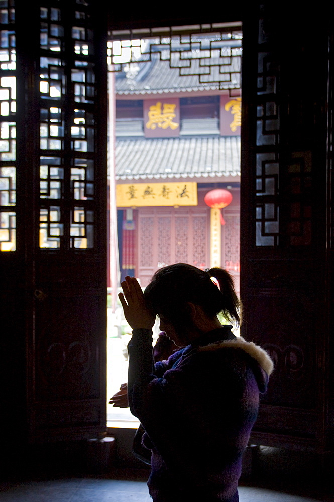 Worshipper praying at the Jade Buddha Temple, Shanghai, China