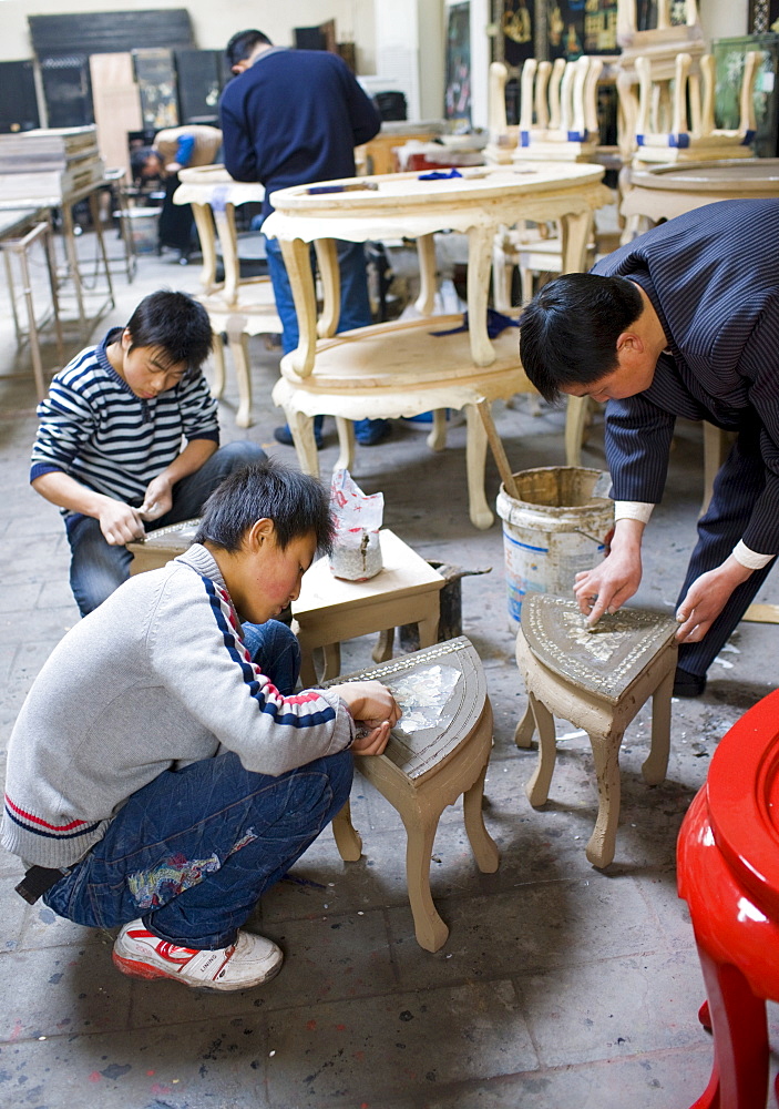 Marquetry craftsmen at work on lacquer tables at souvenir and furniture factory, Xian, China