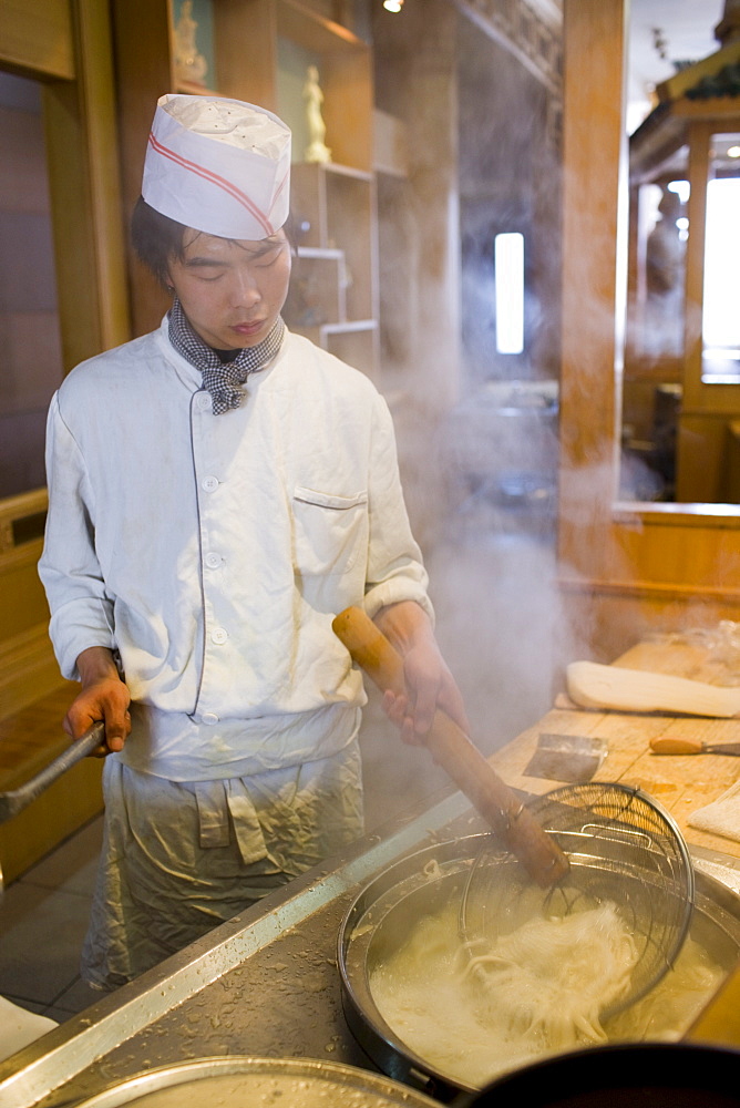 Chef cooking noodles in typical tourist restaurant, Xian, China