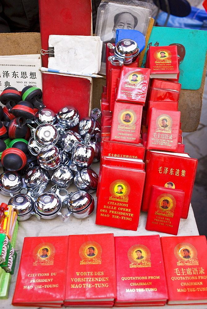 Chairman Mao's Little Red Book and bicycle bells for sale on market stall in Moslem district of Xian, China