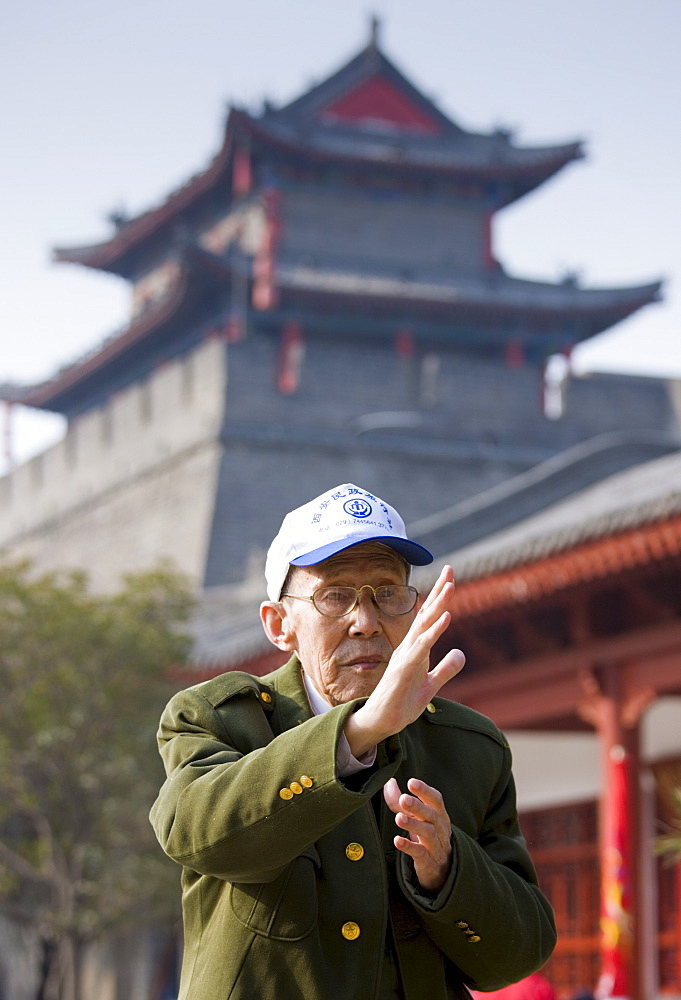 Man practises Tai chi as part of his morning exercise in the park by the City Wall of Xian, China