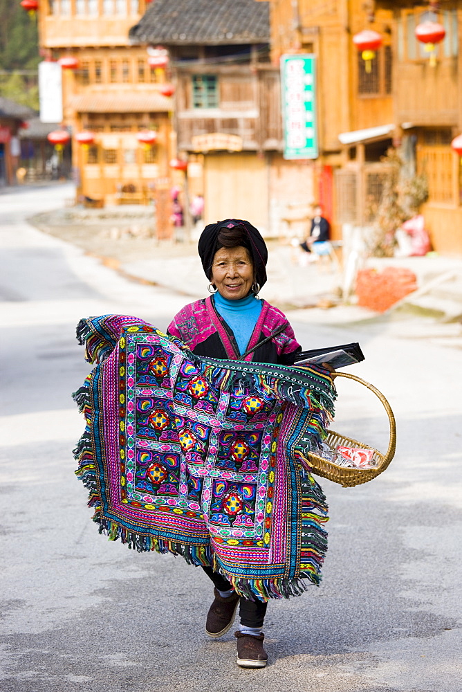 Yao minority group Chinese woman selling traditional rug in Ping An street, near Guilin, China