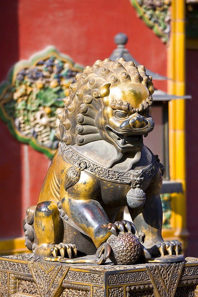 Gilded male lion statue with ball under paw in the Forbidden City, Beijing, China