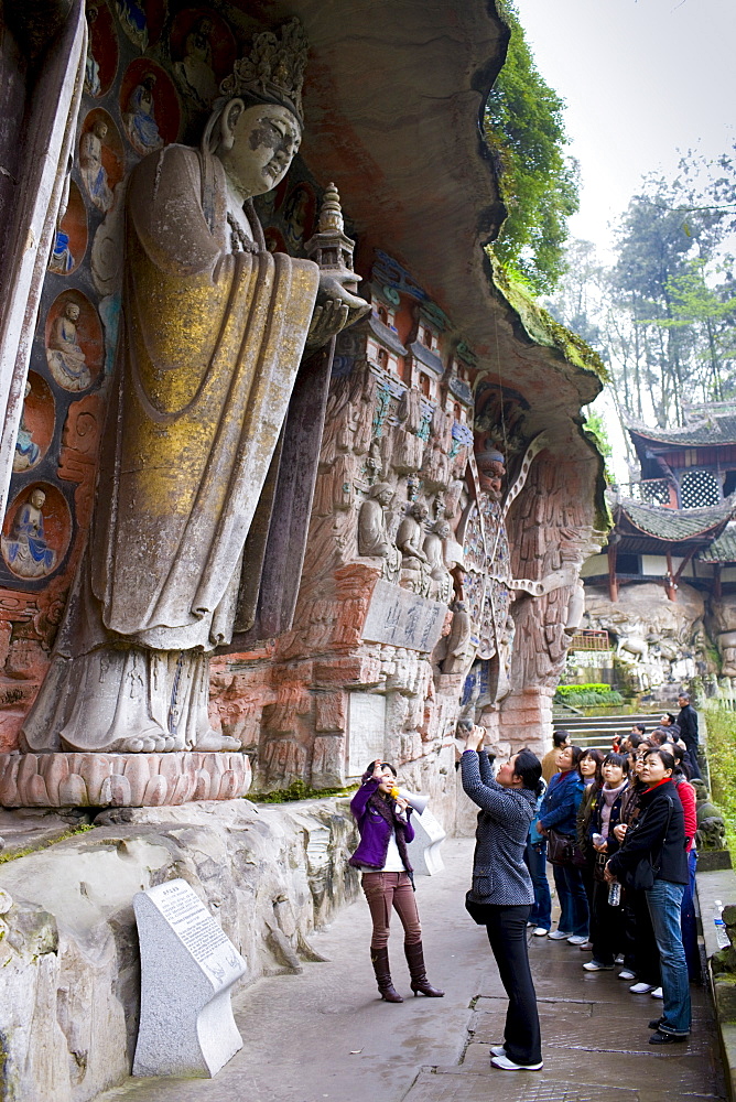 Tourists at Dazu rock carvings of Buddha of Mercy at Mount Baoding, Chongqing, China