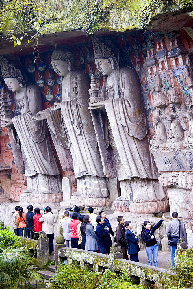 Tourists at Dazu rock carvings of Buddha of Great Sunlight, Buddha of Mercy at Mount Baoding, China