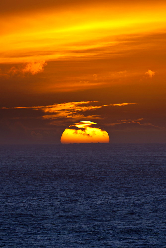 Sun setting in the west over the ocean at Woolacombe, North Devon, UK