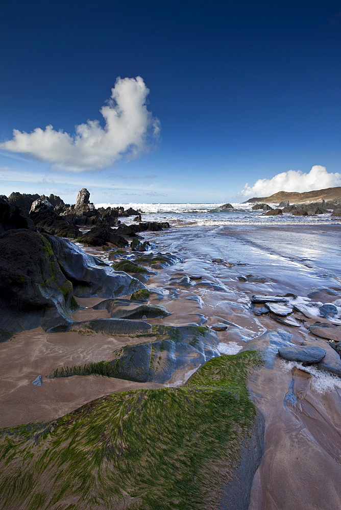 Waves lapping onto the beach at Watersmeet Bay near Woolacombe, North Devon, UK