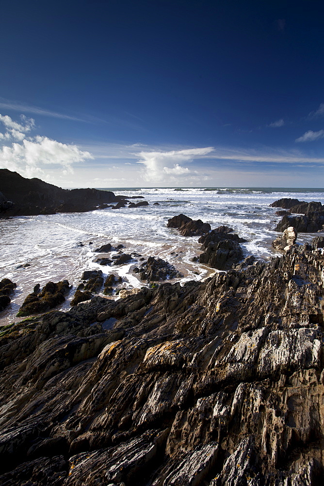 Waves lapping onto the beach at Watersmeet Bay near Woolacombe, North Devon, UK