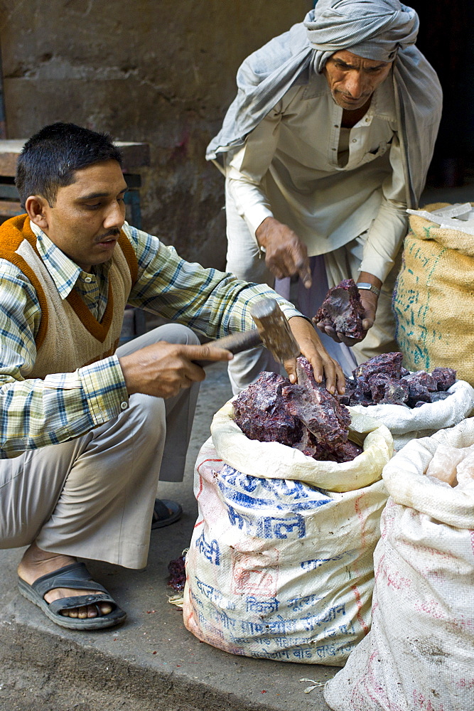 Rock salt being chopped for sale at Khari Baoli spice and dried foods market, Old Delhi, India