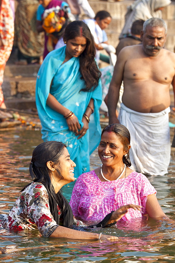 Indian Hindu pilgrims bathing in The Ganges River at Dashashwamedh Ghat in Holy City of Varanasi, Benares, India