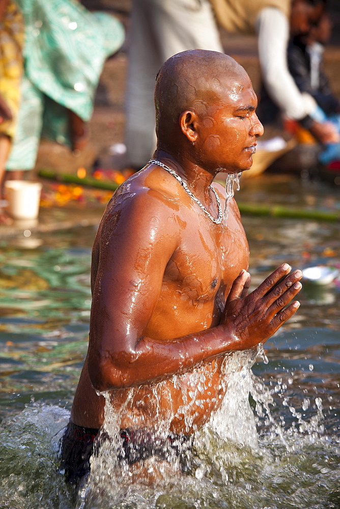 Indian Hindu pilgrims bathing in The Ganges River at Dashashwamedh Ghat in Holy City of Varanasi, Benares, India