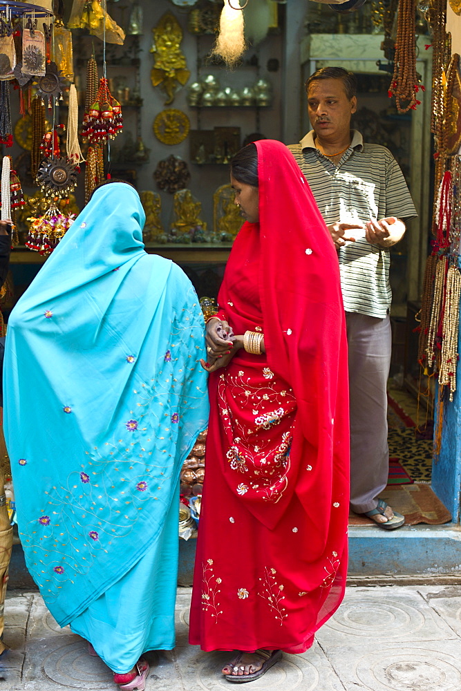 Indian women looking in shop window of jewellery shop in the city of Varanasi, Benares, Northern India