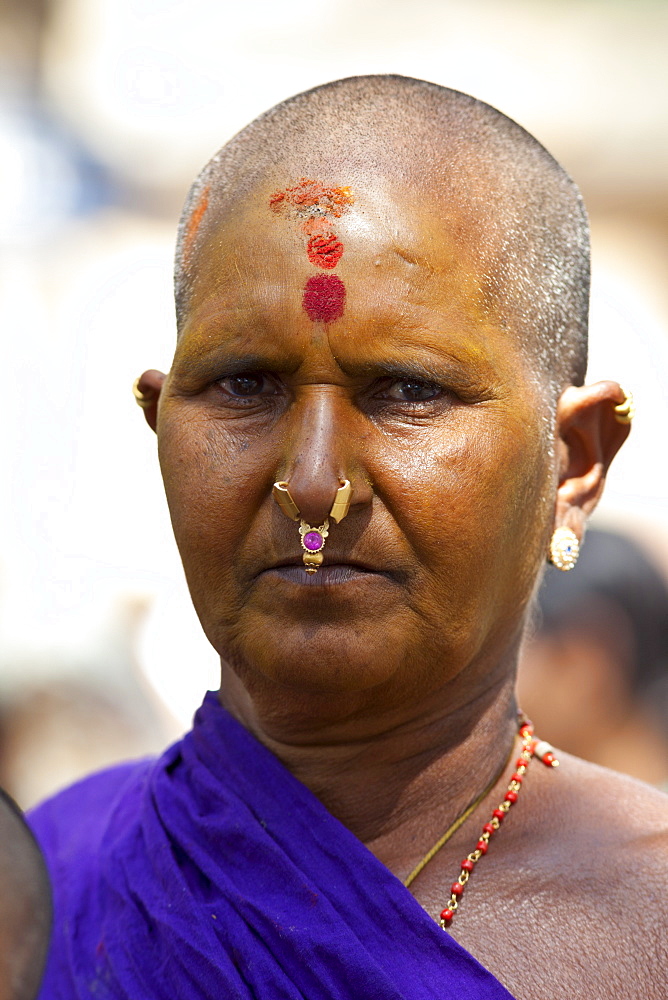 Hindu pilgrim woman with tilaka, bindi mark, nostril ring and yellow facepaint at Vishwanatha Temple (Birla Temple) during Festival of Shivaratri in holy city of Varanasi, India