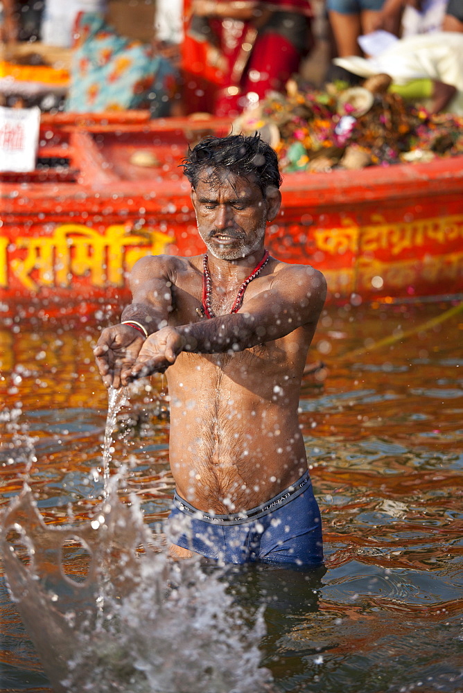 Indian Hindu pilgrims bathing in The Ganges River at Dashashwamedh Ghat in Holy City of Varanasi, Benares, India