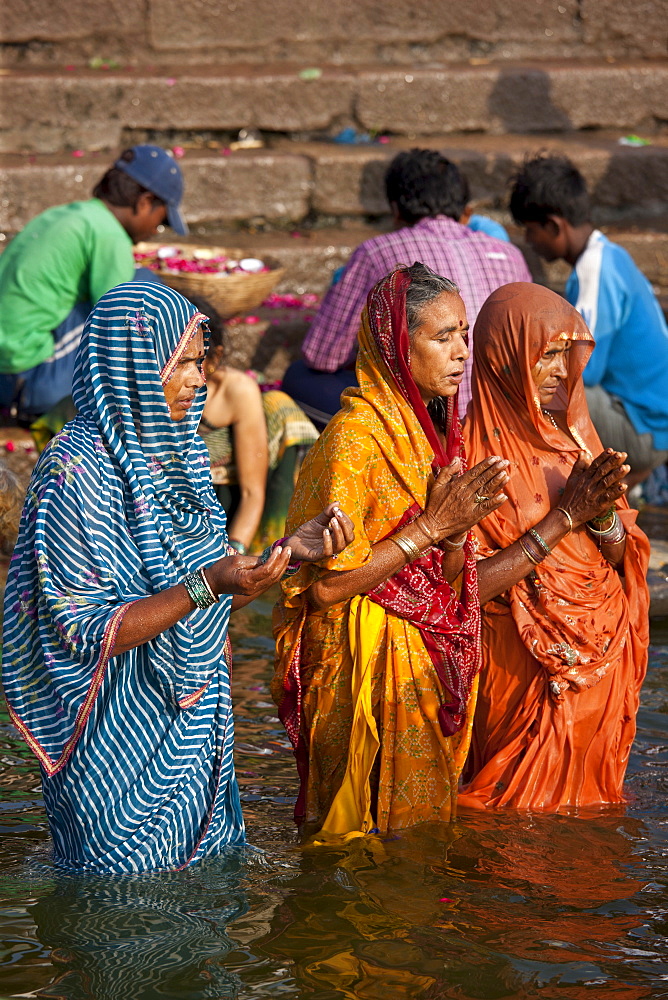 Indian Hindu pilgrims bathing and praying  in The Ganges River at Dashashwamedh Ghat in Holy City of Varanasi, India