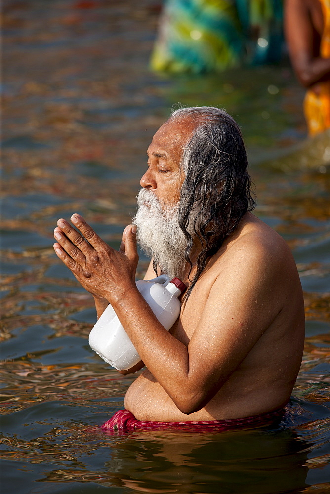 Indian Hindu pilgrim bathing and praying in The Ganges River at Dashashwamedh Ghat in Holy City of Varanasi, India