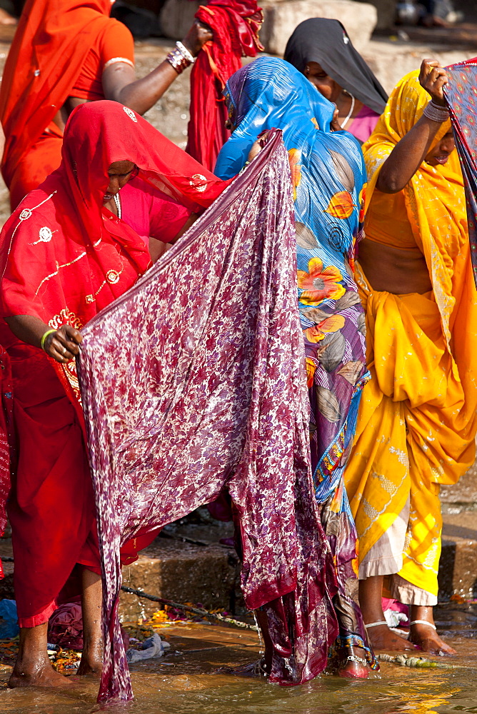 Indian Hindu pilgrims bathing in The Ganges River at Darbhanga Ghat in Holy City of Varanasi, Benares, India